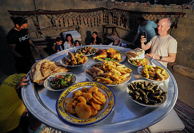 Tourists are seen next to a meal made by Saqqara residents, who sell food to improve their living conditions in thier village, in Giza, Egypt, April 27, 2021. Picture taken April 27, 2021. REUTERS/Shokry Hussien?