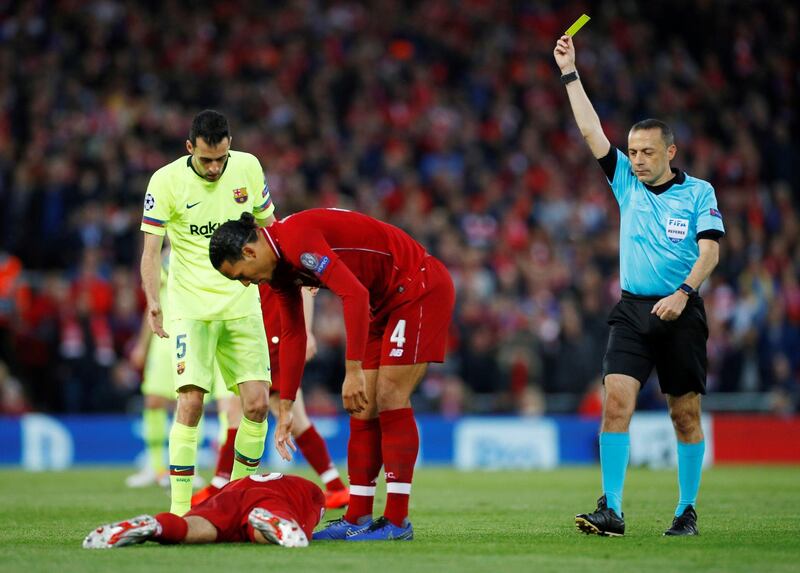 Sergio Busquets is shown a yellow card by referee Cuneyt Cakir after fouling Liverpool's Fabinho Reuters