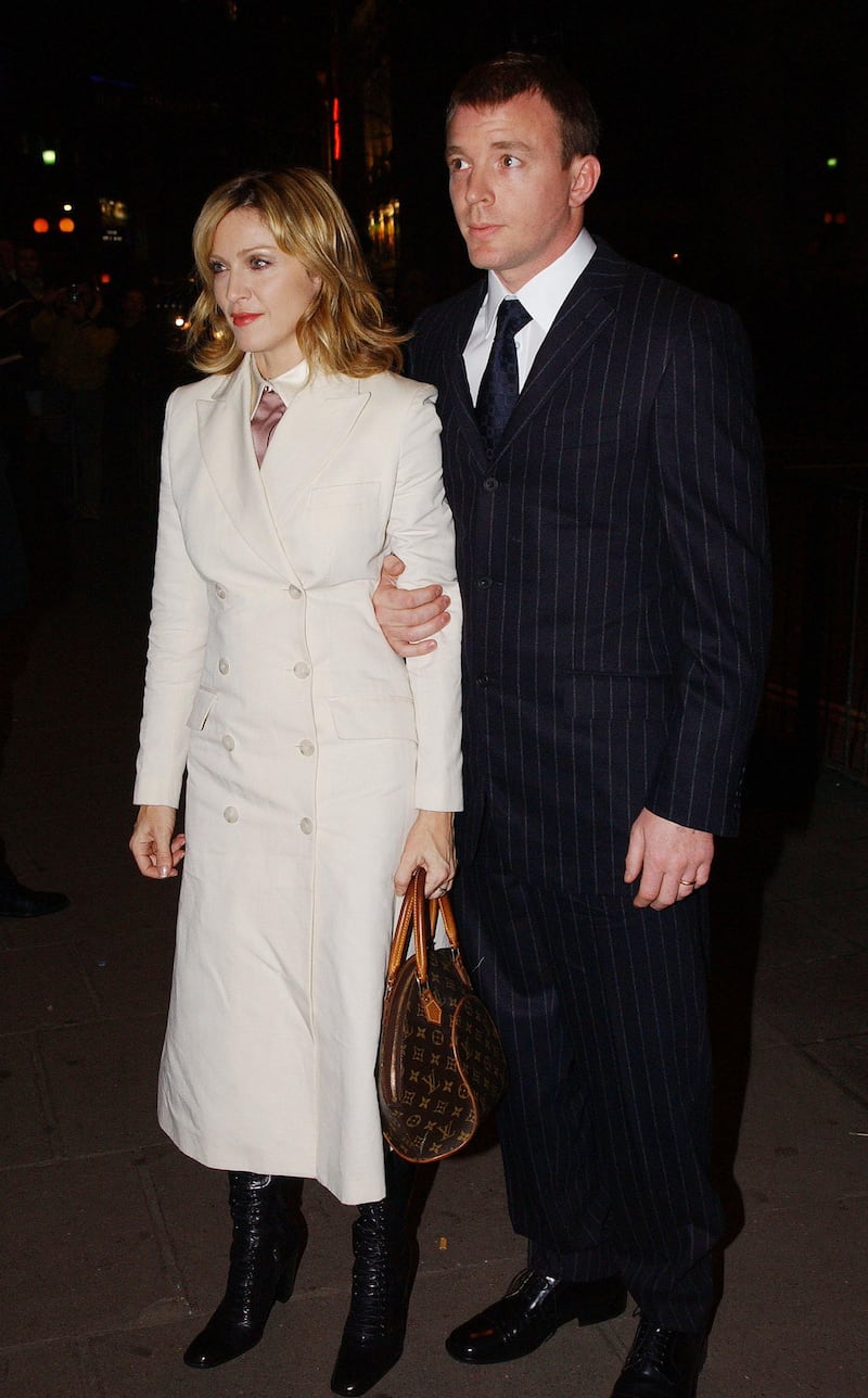 400284 01: Singer and actress Madonna and her husband and film director Guy Ritchie arrive at the opening of the Mario Testino photography exhibition January 29, 2002 at the National Portrait Gallery in London. The exhibition is a retrospective of celebrity portraiture by the acclaimed fashion photographer who has worked for all of the top fashion magazines and shot campaigns for a number of leading fashion houses. 150 works are on display, selected by Testino himself, including prints of Kate Moss, Robbie Williams, John Galliano and Princess Diana. (Photo by Anthony Harvey/Getty Images)