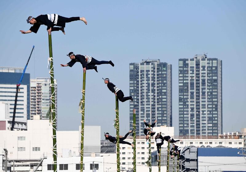 Members of the Edo Firemanship Preservation Association balance on top of bamboo ladders during a presentation at the New Year fire review of the Tokyo Fire Department in Tokyo. Some 2,800 firefighters took part in the annual New Year fire exercises. Toru Yamanaka / AFP