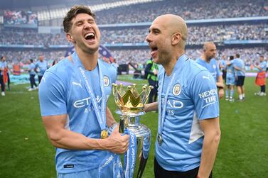MANCHESTER, ENGLAND - MAY 22: John Stones and Pep Guardiola, Manager of Manchester City celebrate with the Premier League trophy after their side finished the season as Premier League champions during the Premier League match between Manchester City and Aston Villa at Etihad Stadium on May 22, 2022 in Manchester, England. (Photo by Michael Regan / Getty Images)