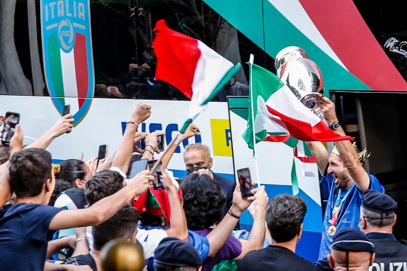 Giorgio Chiellini lifts the Euro trophy in front of Italy fans after Italy arrived at the Parco dei Principi hotel in Rome.