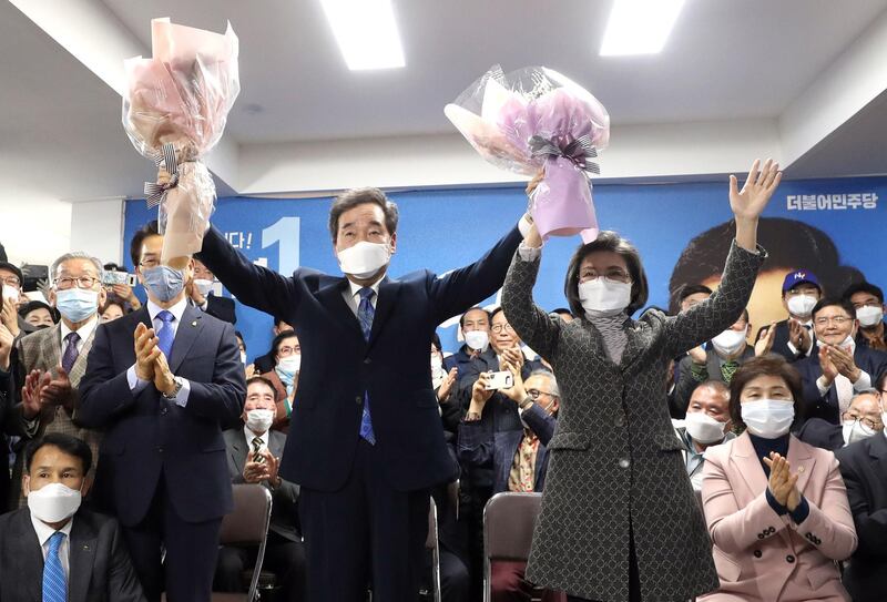 Lee Nak-yon (L), South Korea's former prime minister and candidate of the ruling Democratic Party, and his wife Kim Suk-hee (R) hold flowers in a sign of victory in the parliamentary elections, at his office in Seoul on April 15, 2020.  South Korean voters turned out in force on April 15 to back President Moon Jae-in's handling of the coronavirus epidemic, putting on compulsory face masks and gloves to give his Democratic party a parliamentary majority according to exit polls. -  - South Korea OUT / REPUBLIC OF KOREA OUT  NO ARCHIVES  RESTRICTED TO SUBSCRIPTION USE    
 / AFP / YONHAP / - / REPUBLIC OF KOREA OUT  NO ARCHIVES  RESTRICTED TO SUBSCRIPTION USE    
