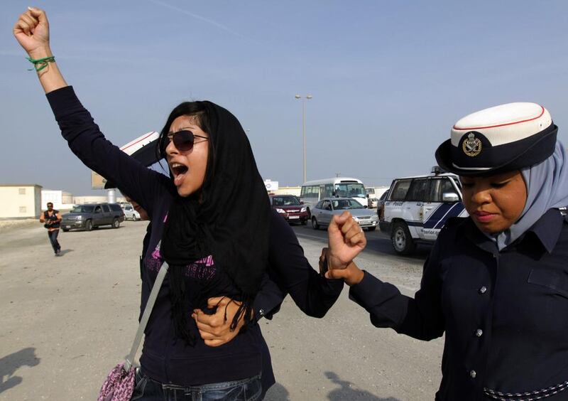 Bahraini activist Zainab Al Khawaja, left, gestures while being arrested by police officers in Eker, Bahrain, on October 21, 2012. Hasan Jamali, File/AP Photo