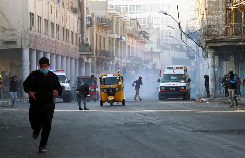Demonstrators run from tear gas. Reuters