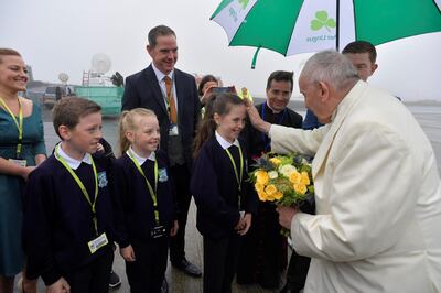 Pope Francis receives flowers from children after arriving in Knock, Ireland August 26, 2018. Vatican Media/Handout via REUTERS ATTENTION EDITORS - THIS IMAGE WAS PROVIDED BY A THIRD PARTY.