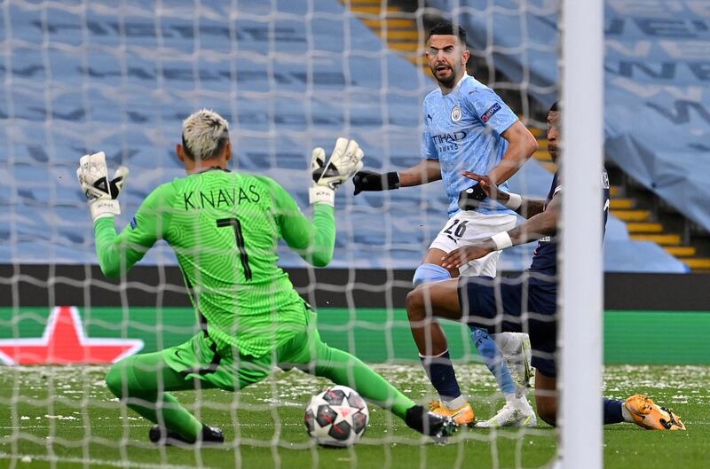 Manchester City's Algerian midfielder Riyad Mahrez (C) scores the opening goal during the UEFA Champions League second leg semi-final football match between Manchester City and Paris Saint-Germain (PSG) at the Etihad Stadium in Manchester, north west England, on May 4, 2021. (Photo by Paul ELLIS / AFP)
