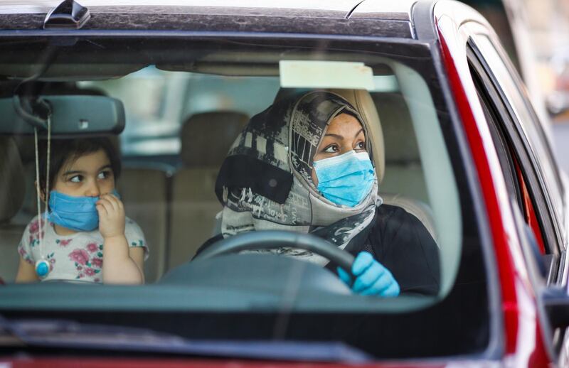 An Iraqi woman wearing a protective face mask, drives past a checkpoint amid the coronavirus, during the month of Ramadan, in Baghdad, Iraq. Reuters