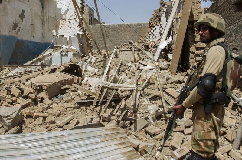 A Pakistani soldier stands near the debris of a house which was destroyed during a military operation against Taliban militants in the  town of Miranshah in North Waziristan in this July 9, 2014 file photo. “It’s a revenge attack for the army offensive in North Waziristan,” Taliban spokesman Muhammad Umar Khorasani told Reuters following the attack at a military-run school in the northwestern Pakistani city of Peshawar on Tuesday. Maqsood Mehdi / Reuters