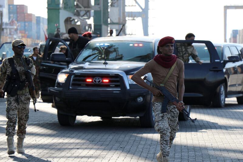 Soldiers escort government officials touring the container terminal at Aden port, Yemen December 12, 2018. Picture taken December 12, 2018. REUTERS/Fawaz Salman