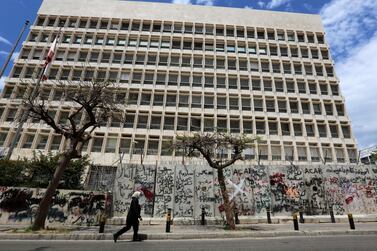 A woman wearing a protective mask walks past Central Bank building in Beirut. Lebanon has eased banking secrecy laws for a one-year period to facilitate a forensic audit of the Central Bank and other state institutions. Reuters