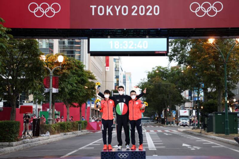From left: silver medalist Koki Ikeda of Team Japan, gold medalist Massimo Stano of Team Italy and bronze medalist Toshikazu Yamanishi of Team Japan pose during the medal ceremony for the Men's 20km Race Walk.