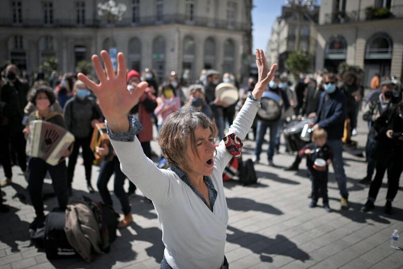 A woman dances as musicians play music during a gathering of protesters who are occupying the Theatre Graslin in Nantes, Western France. AFP