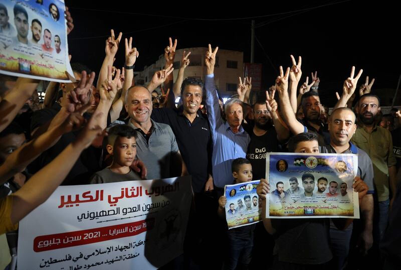 Palestinians flash the "V" for victory sign as they celebrate the escape of six Palestinians from an Israeli prison, in the Jenin camp in the northern Israeli-occupied West Bank, on September 6, 2021. Six Palestinians broke out of a prison in northern Israel prison through a tunnel dug beneath a sink, triggering a massive manhunt for the group that includes a prominent ex-militant.  AFP