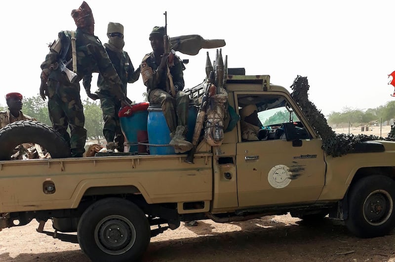 Soldiers of the Chad Army sit on the back of a Land Cruiser at the Koundoul market, 25 km from N'Djamena, on January 3, 2020, upon their return  after a months-long mission fighting Boko Haram in neighbouring Nigeria. Chad has ended a months-long mission fighting Boko Haram in neighbouring Nigeria and withdrawn its 1,200-strong force across their common border, an army spokesman told AFP on January 4, 2020. / AFP / -

