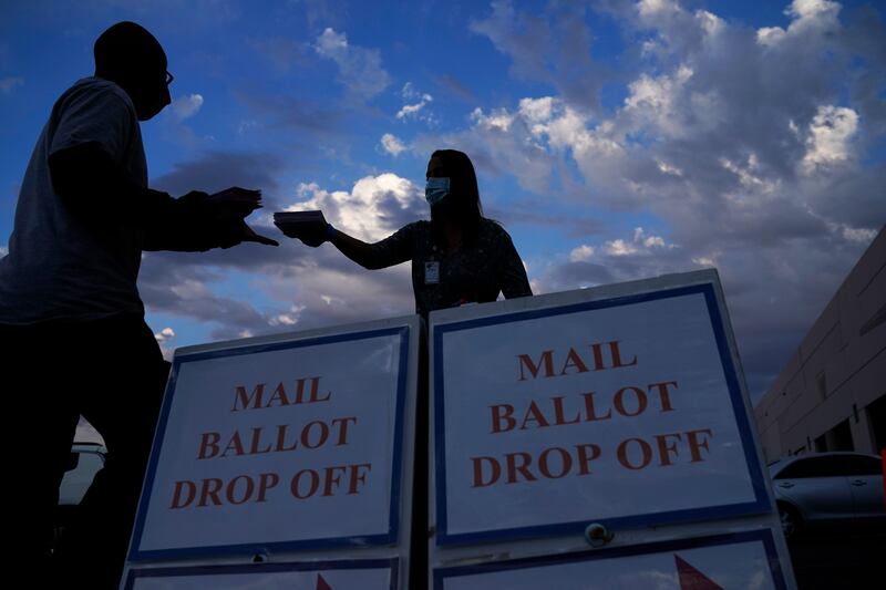 A county worker collects a mail-in ballot in a drop off area at the Clark County Election Department in Las Vegas. AP