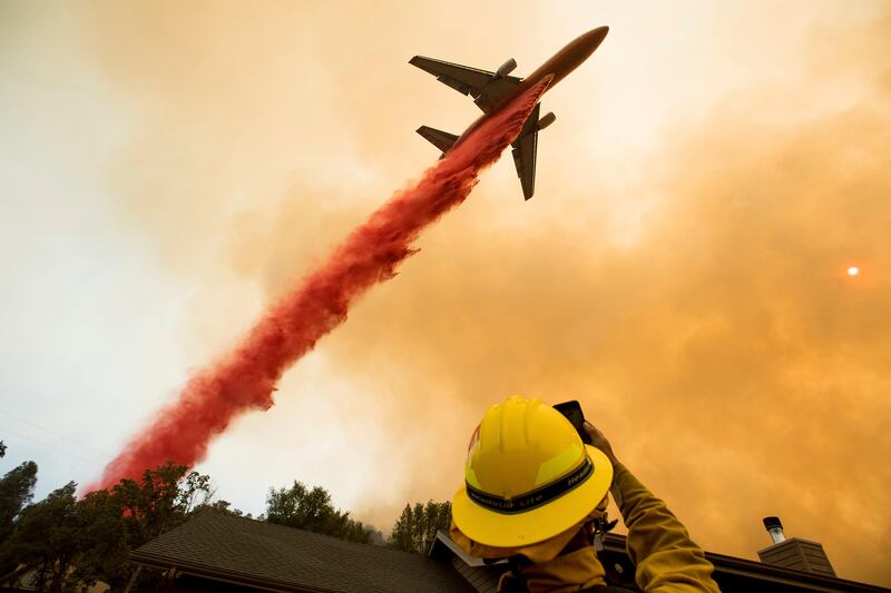 An air tanker drops retardant while battling a wildfire near Mariposa, California. The fire has forced thousands of people from homes in and around a half-dozen small communities, officials said. Noah Berger / AP Photo