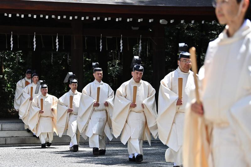 Shinto priests walk towards the main building to conduct a festive ceremony to report the enthronement of the new emperor to the royal family's ancestors at Meiji Shrine in Tokyo.. Japan's new Emperor Naruhito formally ascended the Chrysanthemum Throne, a day after his father abdicated from the world's oldest monarchy and ushered in a new imperial era.  AFP