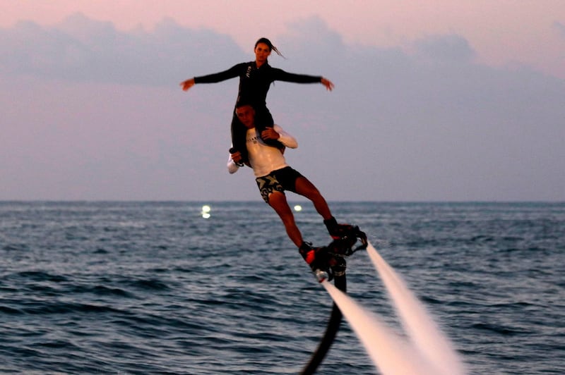 A Lebanese couple ride on a fly board of the coast of Sidon. AFP