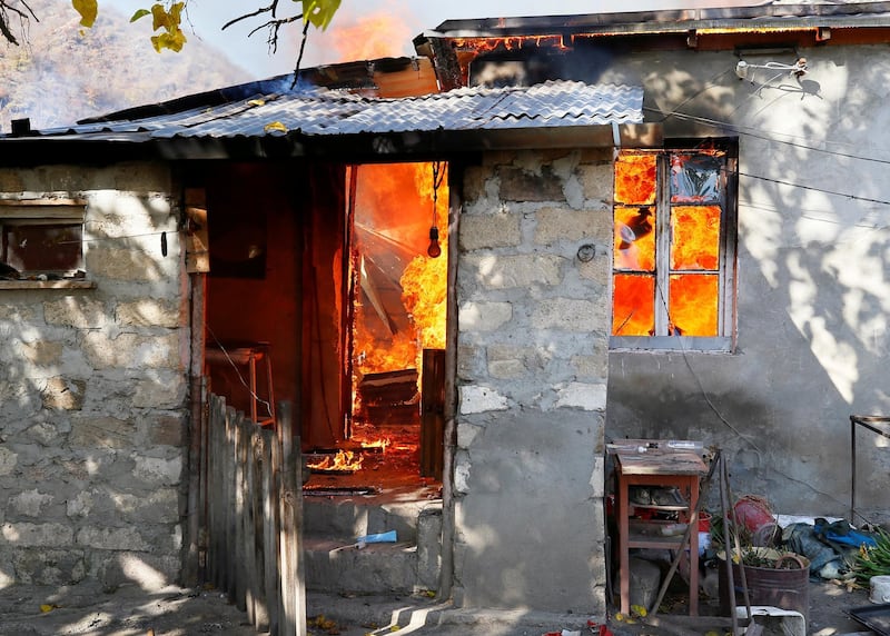 A house is seen set on fire by departing Ethnic Armenians, in an area which had held under their military control but is soon to be turned over to Azerbaijan Reuters