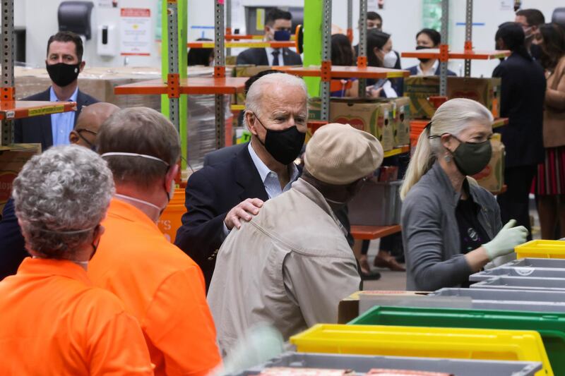 U.S. President Joe Biden talks to people as he visits the Houston Food Bank in Houston, Texas. Reuters