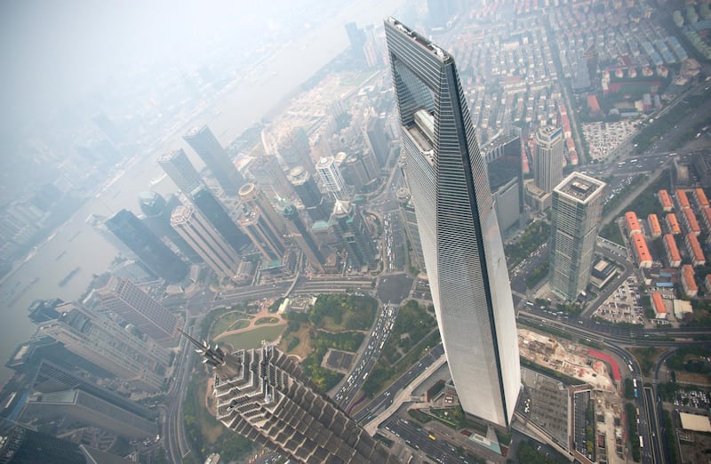 A general view shows the Shanghai World Financial Center and the skyline of the Lujiazui Financial District in Pudong, seen from the 109th floor of the Shanghai Tower (still under construction), covered in smog in Shanghai on October 16, 2014. China has for years been hit by heavy air pollution, caused by enormous use of coal to generate electricity to power a booming economy, and more vehicles on the roads. AFP PHOTO / JOHANNES EISELE (Photo by Johannes EISELE / AFP)