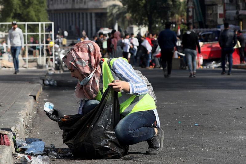 A volunteer picks up trash on the Ahrar Bridge during ongoing anti-government protests in Baghdad. AP Photo