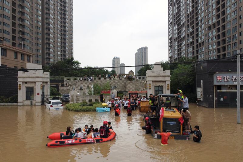 Rescue workers evacuate residents from a flooded residential compound following heavy rainfall in Zhengzhou, Henan province, China