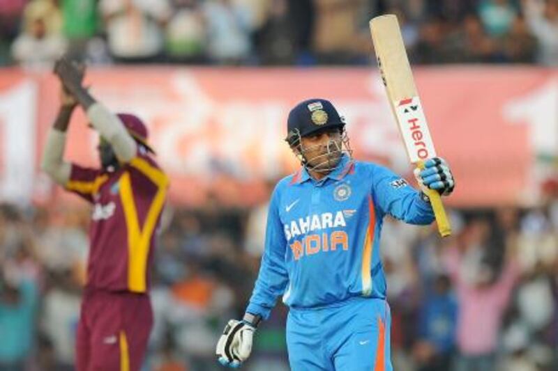 Indian batsman Virender Sehwag raises his bat as he celebrates after scoring 150 runs during the fourth one-day international cricket match between India and West Indies at The Holkar Stadium in Indore on December 8, 2011. AFP PHOTO/Punit PARANJPE
 *** Local Caption ***  432113-01-08.jpg