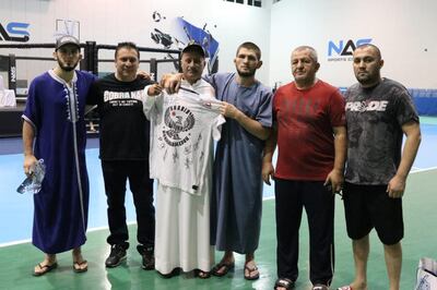 Khabib Nurmagomedov (third from right), with his father Abdulmanap Nurmagomedov (second from right) and Umidjon Mavlyanov (far right), presenting a t-shirt to Ahmad Jaber Al Harbi at Nad Al Sheba Sports Complex in Dubai. Courtesy Umidjon Mavlyanov
