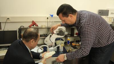 Gazan engineers Esam Khalafallah (R) and Ismail Abu Skheila (L) working on their ventilator prototype.
