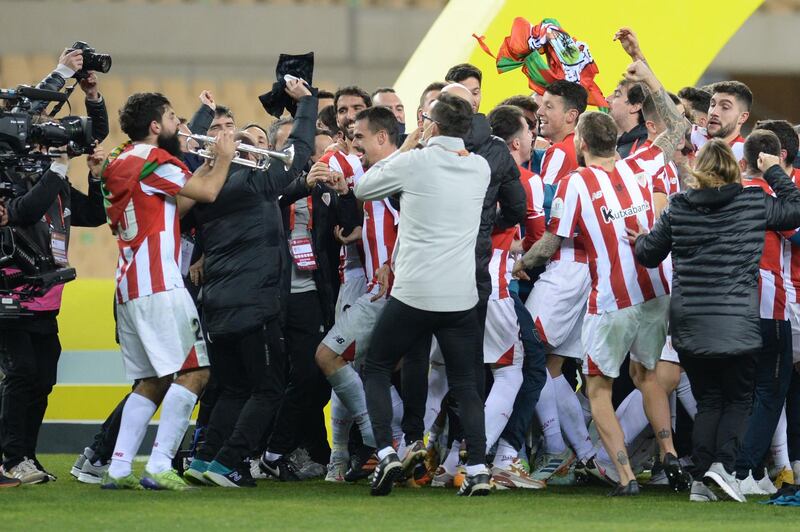 Athletic Bilbao's Spanish forward Asier Villalibre plays trumpet as he celebrates with teammates after the match. AFP
