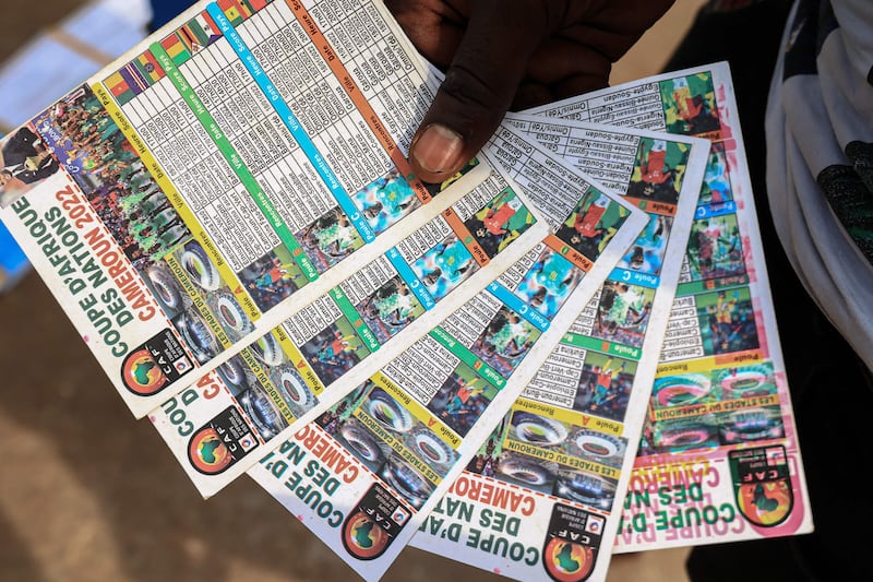 A vendor holds schedules for the Africa Cup of Nations in Yaounde, Cameroon. AFP
