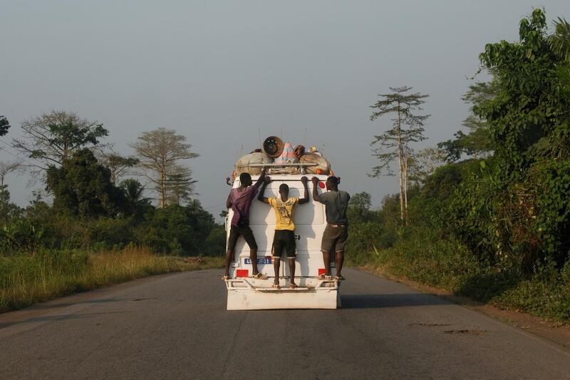 People ride on the back of a minibus to the town of Soubre, in the south-western Ivory Coast. Reuters