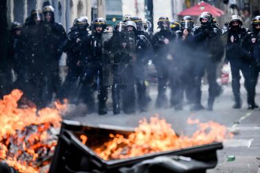 Riot Police look towards a burning barricade amid clashes with protestors during a demonstration on May Day (Labour Day), to mark the international day of workers, more than a month after the government pushed an unpopular pensions reform act through parliament, in Nantes, northwestern France, on May 1, 2023.  - Opposition parties and trade unions have urged protesters to maintain their three-month campaign against the law that will hike the retirement age to 64 from 62.  (Photo by LOIC VENANCE  /  AFP)
