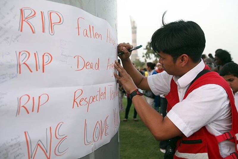 Doha, Qatar, May 29, 2012:

A cross section off Doha came out to Aspire Park today in honor of the victims who were kill in a tragic fire at the nearby Villagio mall. People from literally every community came out in an act of solidarity that could be considered rare for such a young burgeoning place that is seeking to find its identity with a large influx of foreign workers.
Troy Ojas of the Qatar Red Crscent writes out "To all the fallen heroes, our deepest condolences from QRC"  on the wall of rememberance.

Lee Hoagland/The National