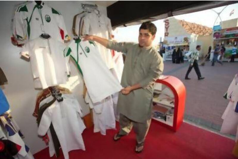 Saeed Almrshedi in his store that sells kanduras at Global Village, Dubai in the colours of football teams. Jaime Puebla / The National