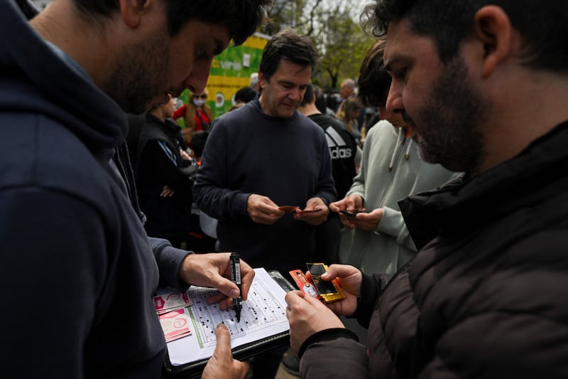 Men exchange Panini World Cup football stickers at Rivadivia park in Buenos Aires. AFP