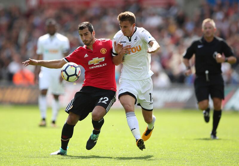 Manchester United's Henrikh Mkhitaryan, left, and Swansea City's Tom Carroll battle for the ball during their English Premier League soccer match at the Liberty Stadium, Swansea, Wales, Saturday, Aug. 19, 2017. (Nick Potts/PA via AP)