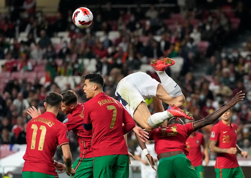Serbia's Nikola Milenkovic, top, duels for the ball with Portugal's Cristiano Ronaldo. AP Photo