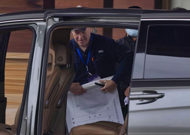 A member of the World Health Organisation team tasked with investigating the origins of the coronavirus disease in Wuhan, China, leaves a hotel with a chart of the Huanan seafood market. EPA