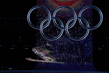 FILE - Olympic rings illuminate the national stadium during the opening ceremony of the 2022 Winter Olympics, Friday, Feb.  4, 2022, in Beijing.  When former members of the U. S.  snowboarding team sought to report sex-abuse allegations against a longtime coach, they received conflicting information that left them unsure of where to turn — or whether they wanted to pursue the cases at all.  (AP Photo/David J.  Phillip, File)