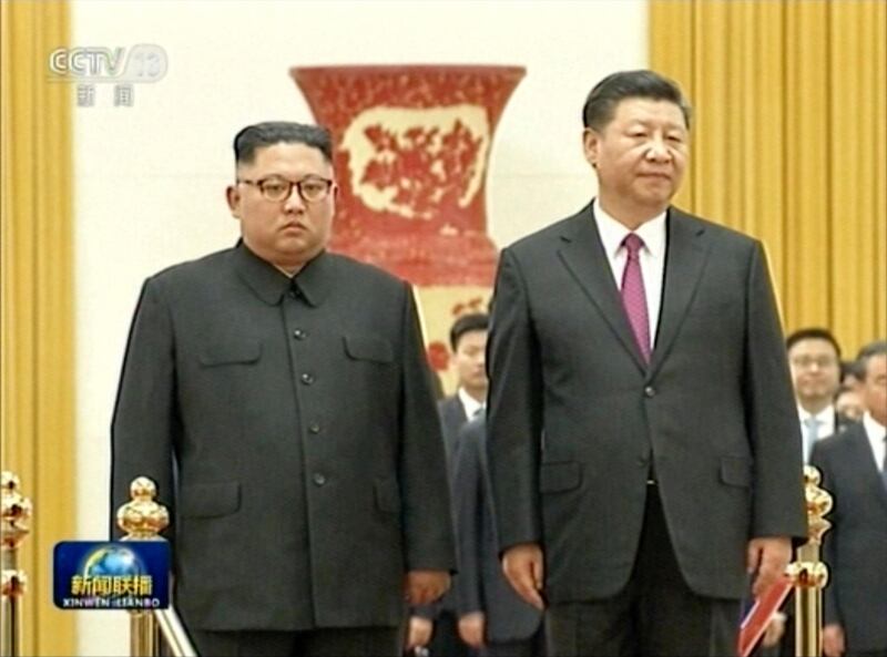In this image taken from a video footage run by China's CCTV on June 19, 2018, via AP Video, Chinese President Xi Jinping, right, stands next to North Korean leader Kim Jong Un during a welcome ceremony at the Great Hall of the People in Beijing. (CCTV via AP Video)