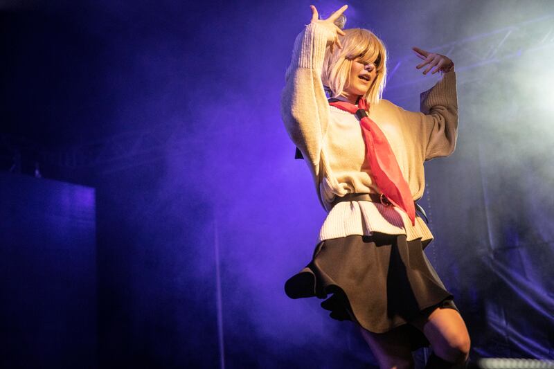 A woman in cosplay performs on stage.