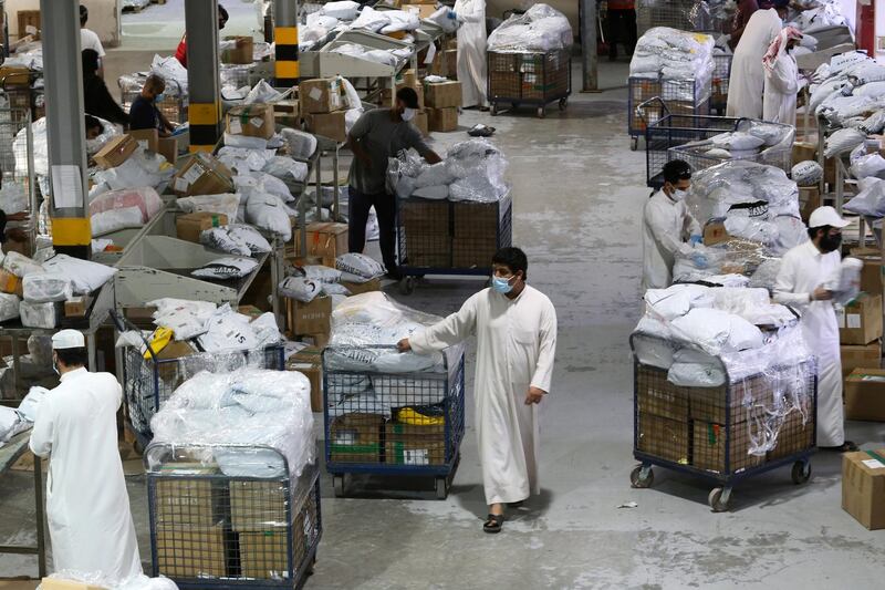 Saudi employees wear a protective maskes as they sort out boxes at the warehouse of Naqel Company Express, after the announcement of the easing of lockdown measures amid the coronavirus disease (COVID-19) outbreak, in Riyadh, Saudi Arabia June 9, 2020. Picture taken June 9, 2020. REUTERS/Ahmed Yosri