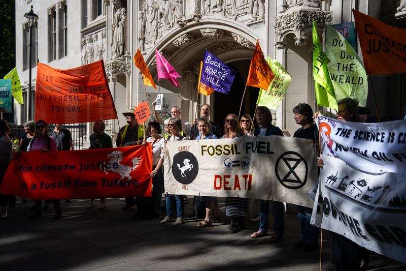 Activists gather outside the Supreme Court in London before a landmark ruling that Surrey Council should have considered the climate impact of burning oil from new wells. Getty Images
