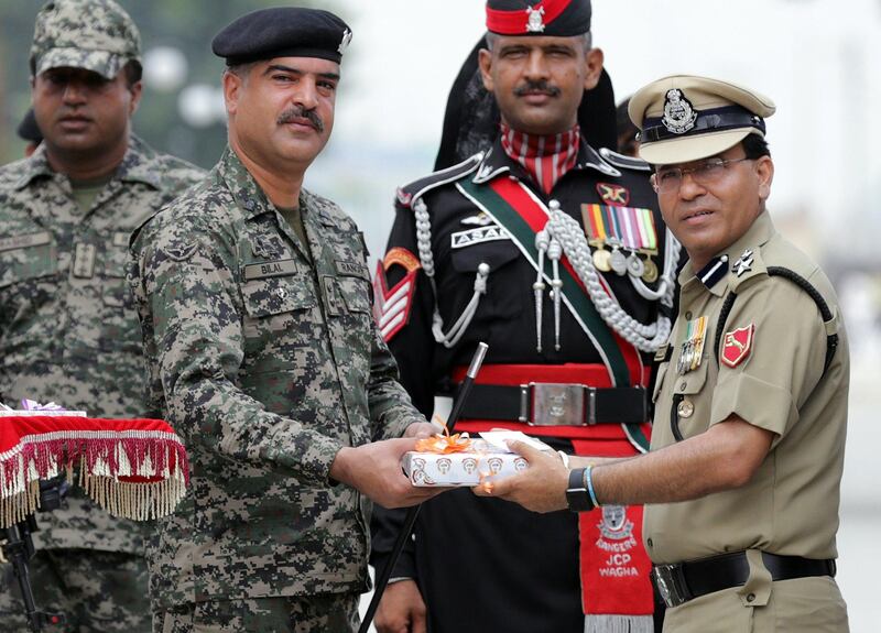 epa06145119 Indian Border Security Force (BSF), Commandant, Sudeep (R), offers a box of sweets to Pakistan Rangers, Wing Commander Bilal (2-L) as Pakistani Rangers soldiers stand nearby on the occasion of India's Independence Day at India-Pakistan Joint Check Post (JCP) Attari, some 30 km from Amritsar, India, 15 August 2017. India is celebrating its 70th year of independence from British rule on 15 August 2017.  EPA/RAMINDER PAL SINGH