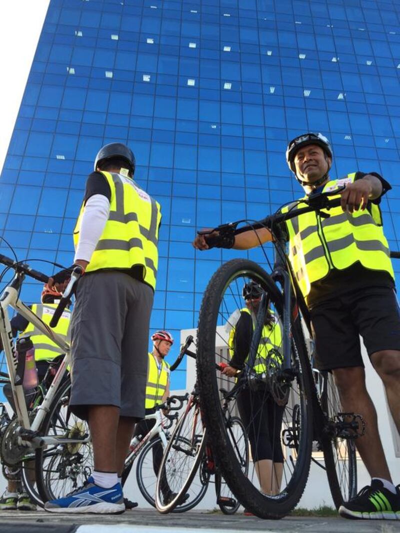 RAK Bank employees arrive at their office after taking part in The Nationals Cycle to Work day. Pawan Singh / The National