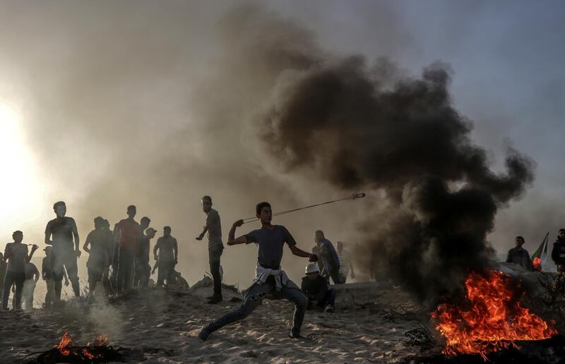 A Palestinian protester throws stones with his slingshot during clashes near the border between Israel and the Gaza Strip. EPA