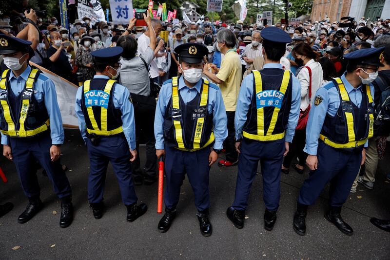 Police officers stand guard in Tokyo during a protest against the funeral. Reuters